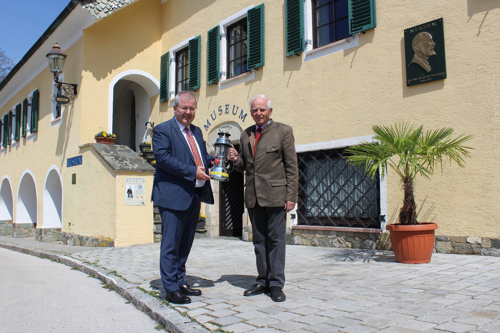 Bürgermeister Walter Zemrosser (links) mit Roland Adunka, Leiter des Auer von Welsbach-Museum, vor dem Museums-Gebäude in der Altstadt Althofens (Foto: Stadtgemeinde Althofen)